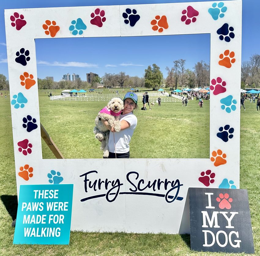 A Bark Baller and her dog posing in a Furry Scurry photo frame