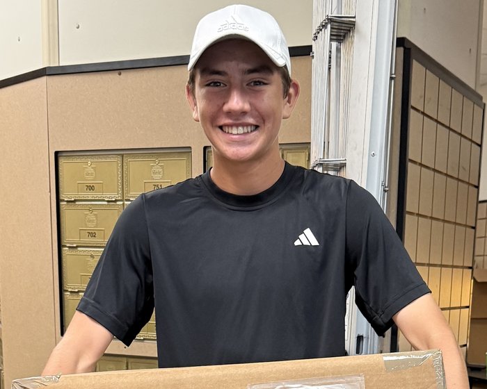 Alejandro Palacios holding a packed Bark Balls shipment ready to send